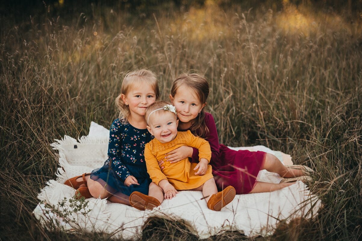 happy kids in a field girls family photography Katie Anton