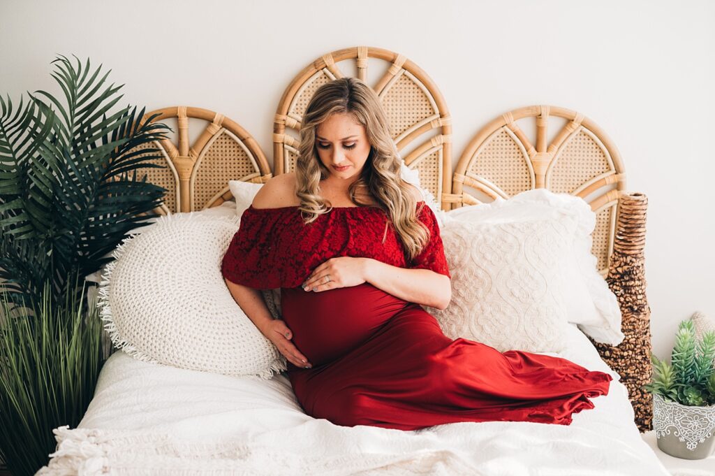 pregnant mom on bed in red dress