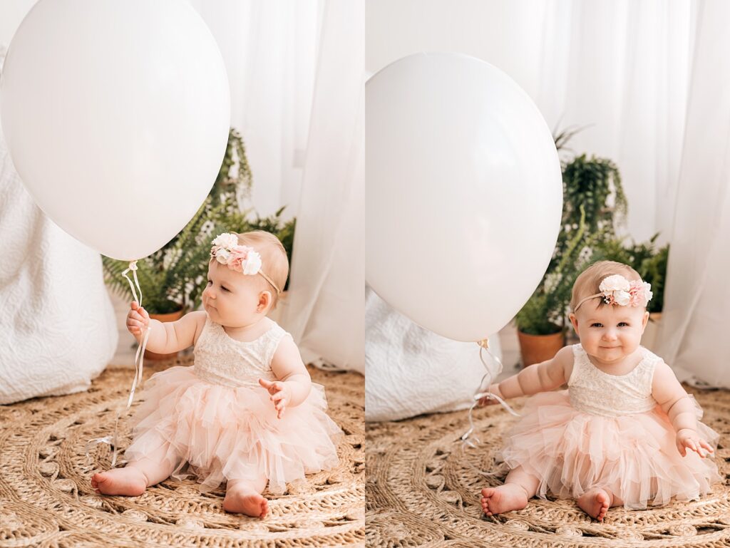 one year old holding giant white balloon