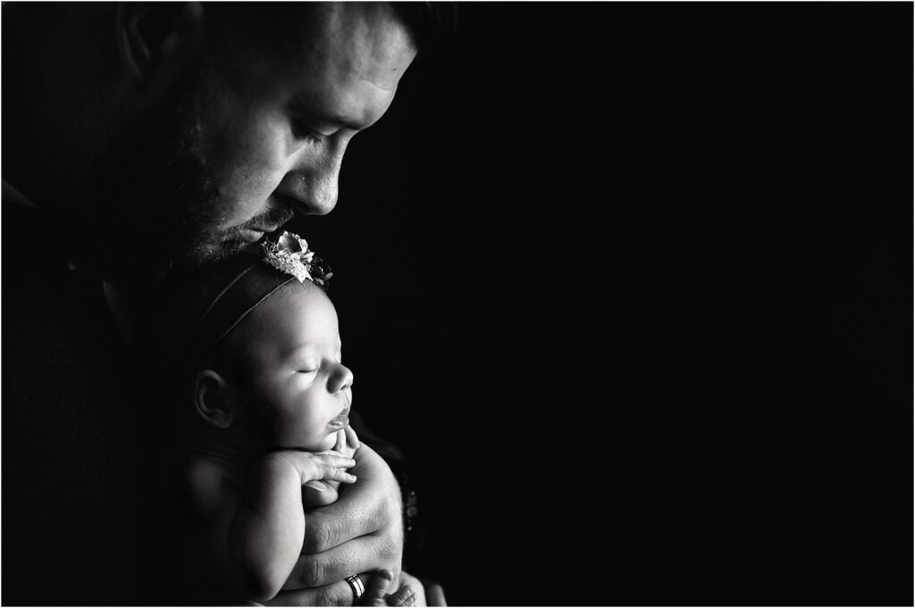 black and white profile photo of dad with baby girl