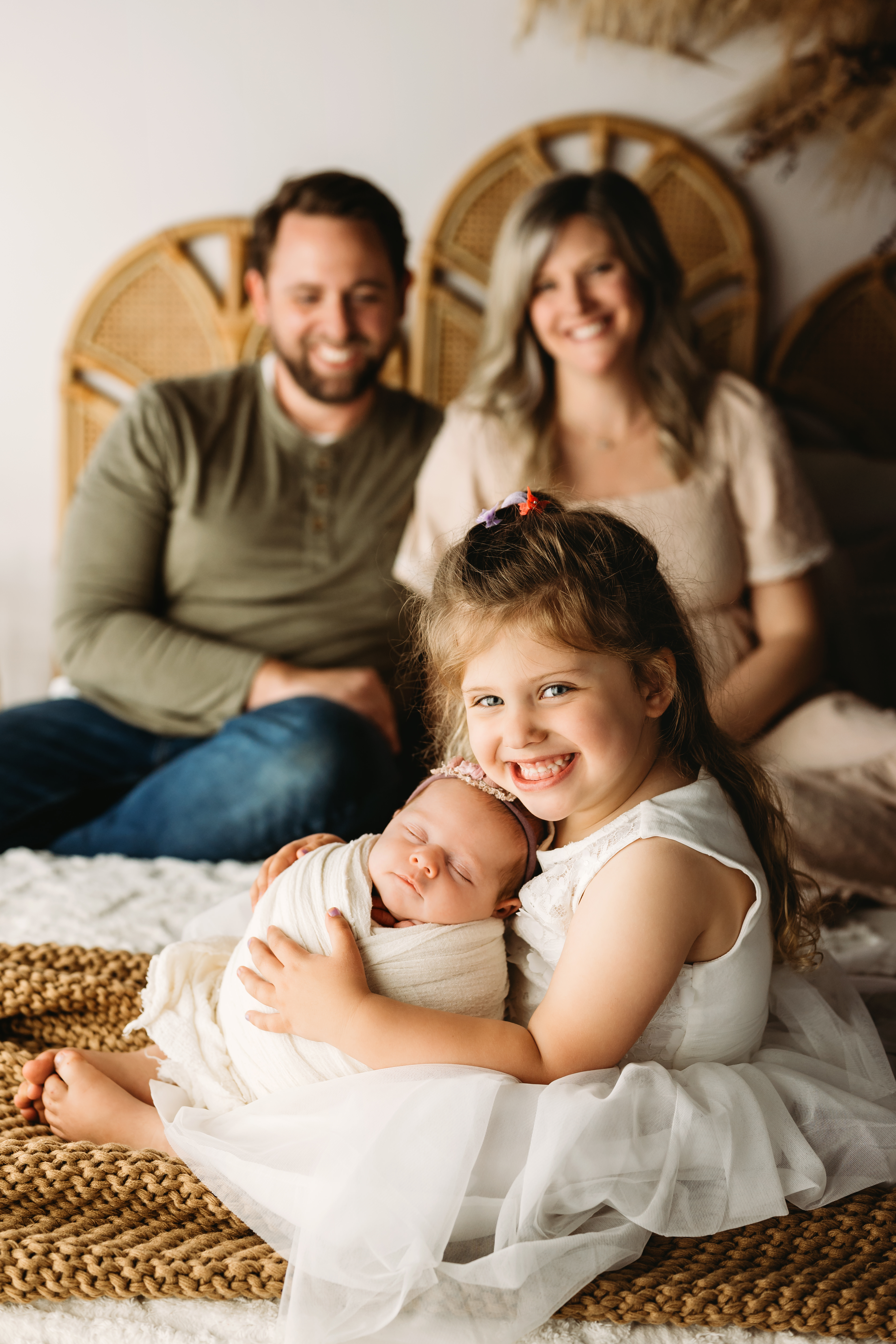 big sister snuggles baby sister at newborn session